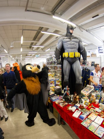 Baseball the flying fox posing with a big Batman statue.