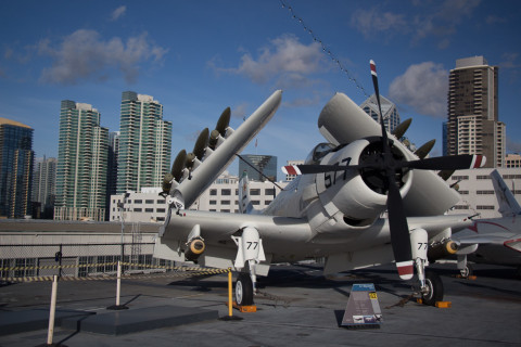 An airplane in front of the San Diego Skyline.