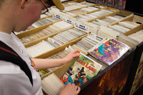Henrieke browsing through funny superhero comics.